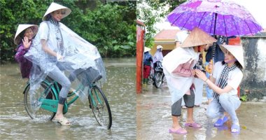 Hoa hậu Phạm Hương chạy xe đạp chở cụ già trong cơn mưa dầm